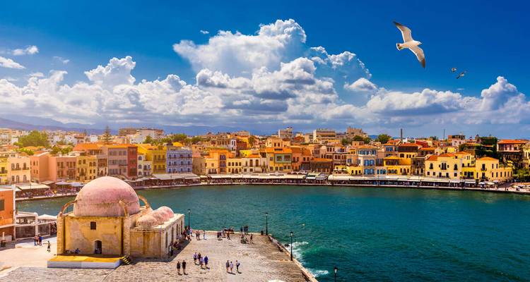 Farbenfroher venezianischer Hafen mit Kuppelmoschee, Ufergebäuden und türkisfarbenem Golf unter dramatischen Wolken und kreisenden Möwen.