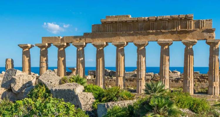Ruines d'un ancien temple grec avec une toile de fond de mer et de ciel bleus.