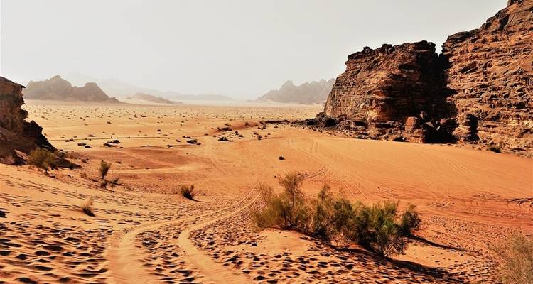 Paisaje desértico con dunas de arena y formaciones rocosas.