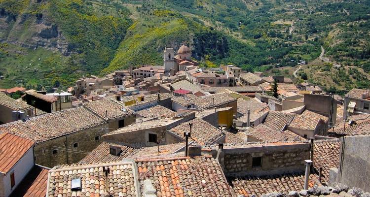 Village traditionnel sur une colline avec un clocher d'église et le paysage environnant.