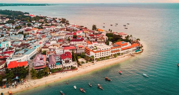 Luftaufnahme von Stone Town, Sansibar, mit bunten Dächern und Stränden.