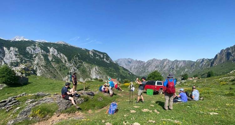 Grupo de excursionistas descansando en un paisaje montañoso.