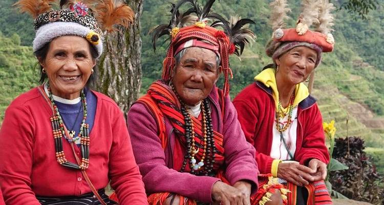 Des femmes âgées en vêtements traditionnels sur une terrasse.