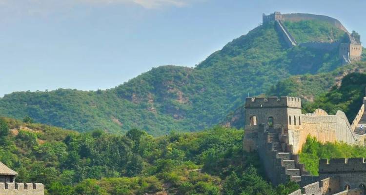 Les tours de guet et les murs crénelés de la Grande Muraille sinuant sur les collines chinoises boisées.