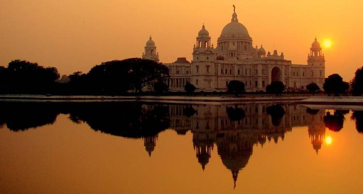 Een historisch gebouw met een weerspiegeling in het water tijdens zonsondergang.