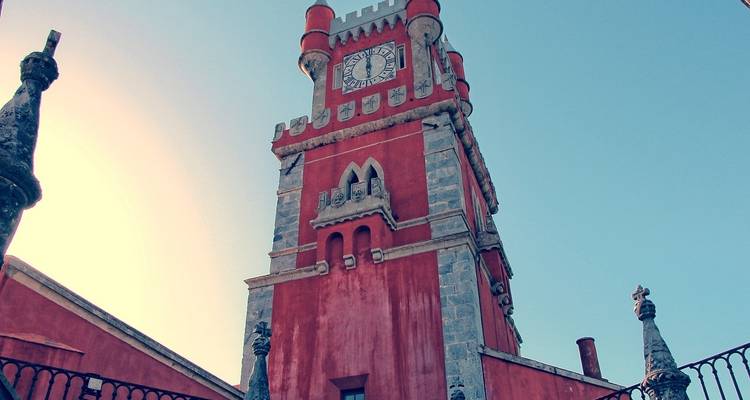 Torre de reloj roja histórica en medio de un cielo despejado.