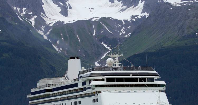 Bateau de croisière devant des montagnes enneigées.