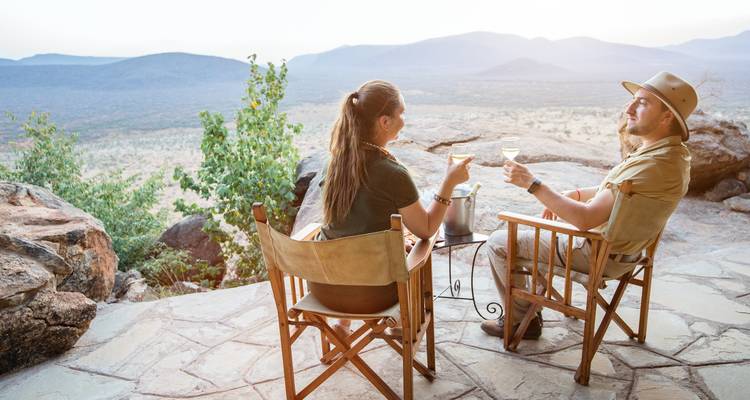 Couple enjoying drinks on a terrace with panoramic views.