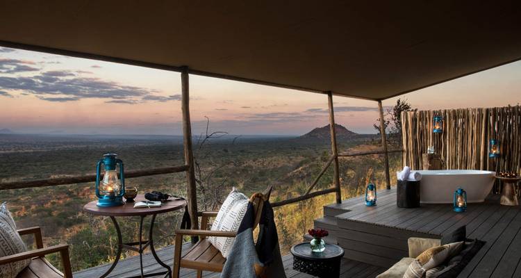 Luxurious tent with a view of the expansive landscape at dusk.