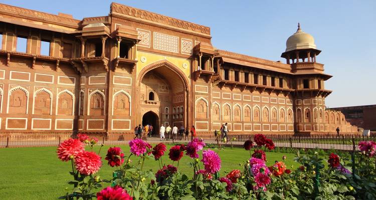 Agra Fort met bloemen op de voorgrond en heldere lucht.