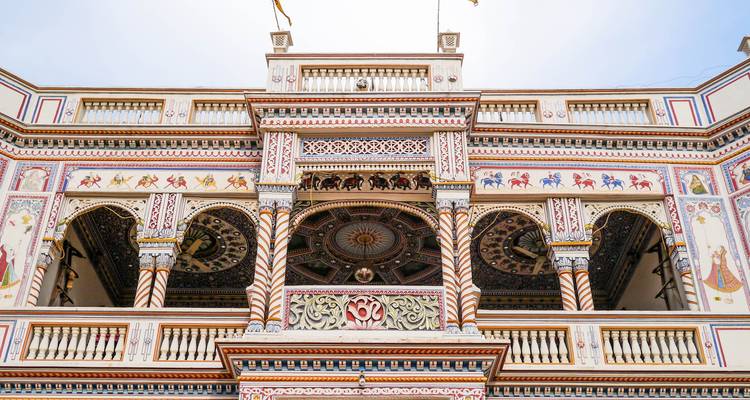 Close-up van een versierde haveli met kleurrijke fresco's.