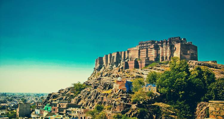 Een groot fort dat uitkijkt over een stad vanaf een heuveltop.