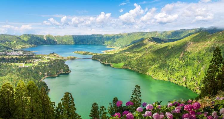 Panoramablick über die smaragdgrünen Zwillingsseen von Sete Cidades, umgeben von üppigen vulkanischen Bergen und Hortensien.