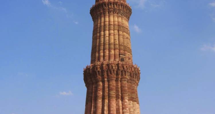 Historic tall minaret with sky in the background.