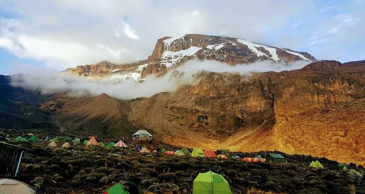 View of Mount Kilimanjaro with tents in foreground.