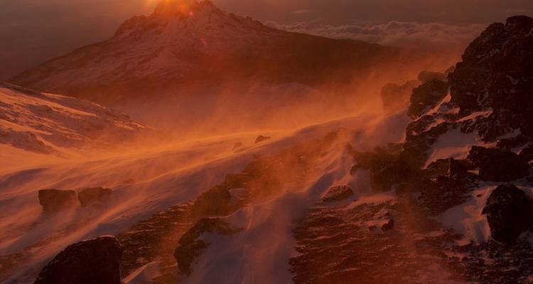 Fiery sunset over snow-blown rocky landscape