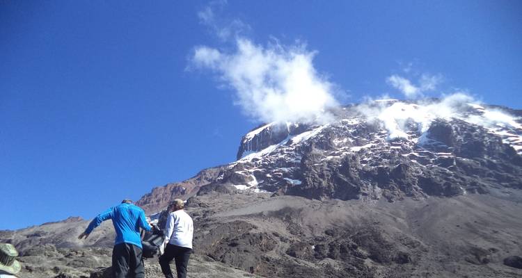 Two people walking with Kilimanjaro in the background.