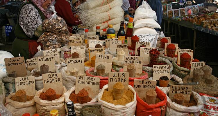 Étal de marché avec une variété d'épices étiquetées en caractères russes.