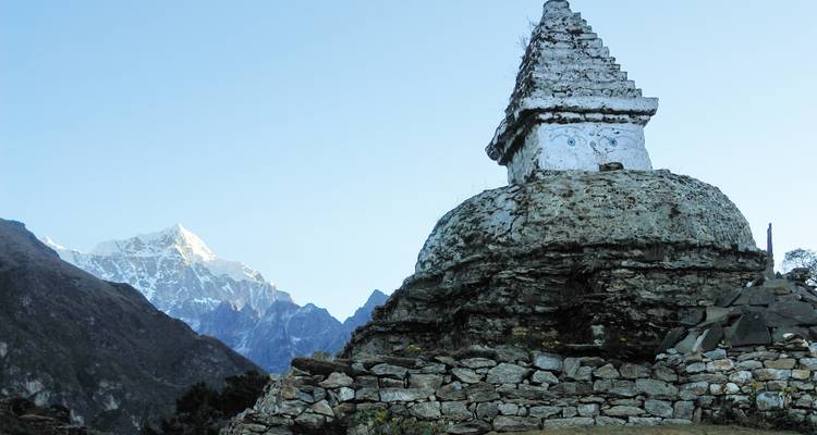 Chorten en pierre avec des montagnes en arrière-plan.