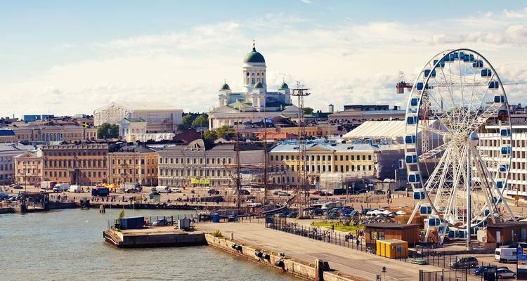 Una escena costera con una noria y una catedral histórica en Helsinki.