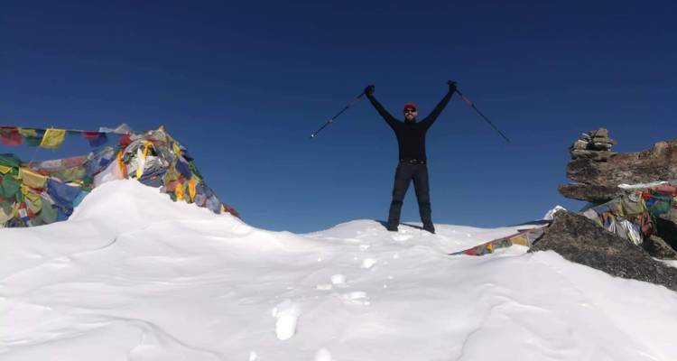 Personne debout triomphalement avec des bâtons de marche dans la neige.