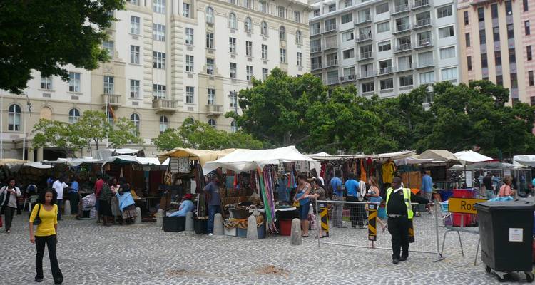 Outdoor market scene with people and various stalls.