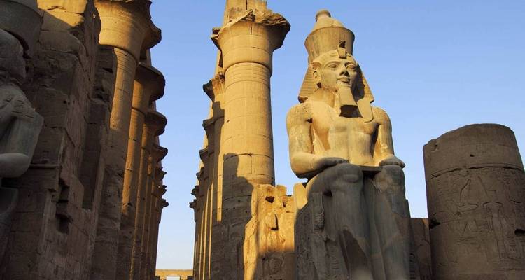 Ancient statue amidst stone pillars and carvings.