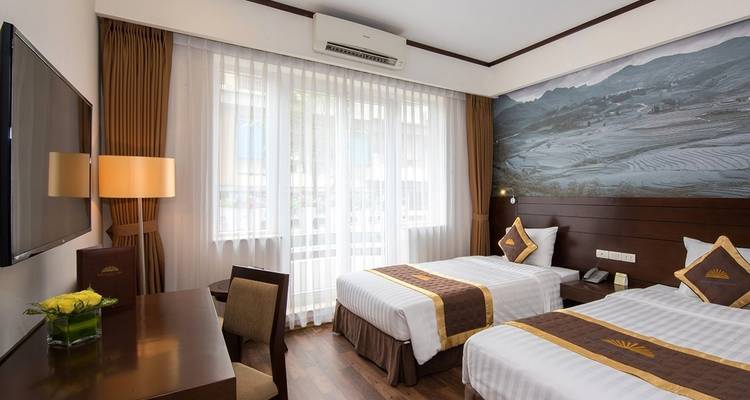 Modern hotel room with twin beds and a mural on the wall.