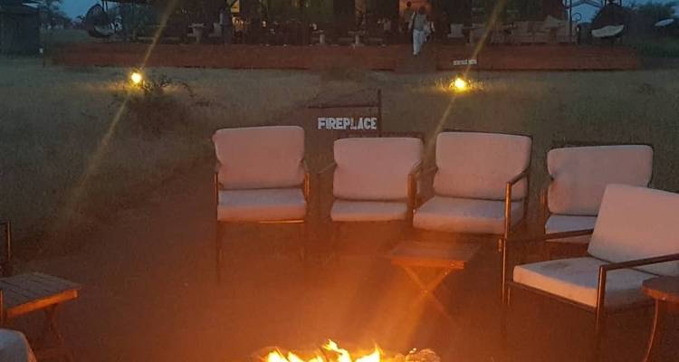 Seating around a fireplace at an outdoor camp
