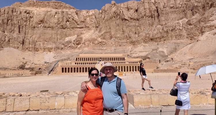 Turistas frente a una estructura egipcia antigua escalonada.