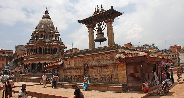 Place historique avec des bâtiments ornés et des gens qui se promènent.