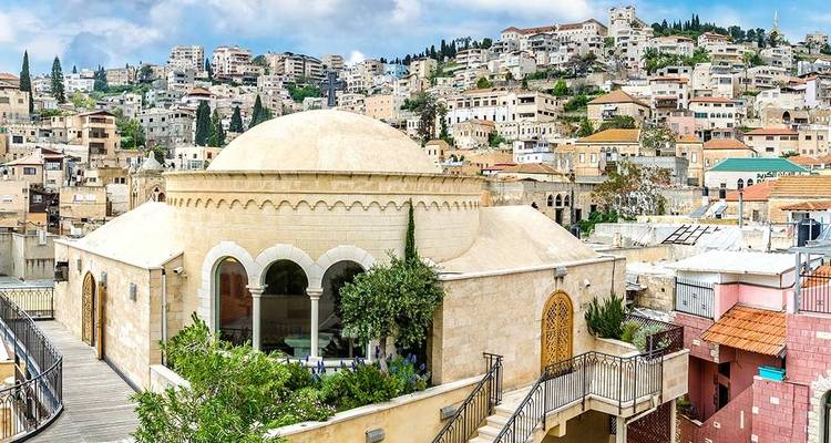 View of a city with a dome-shaped building and hillside.