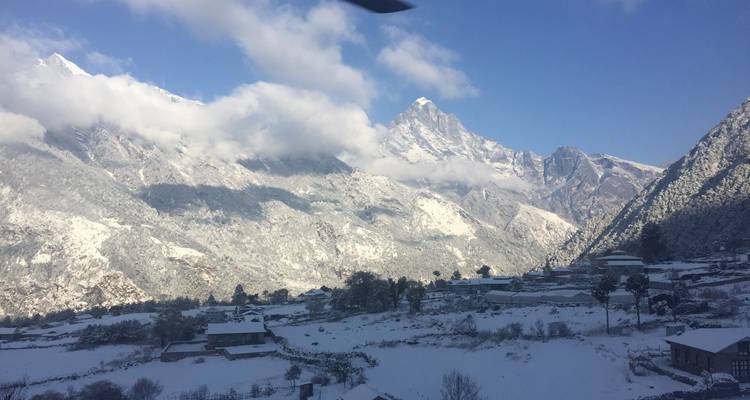 Snow-covered mountains with a small village in the valley.