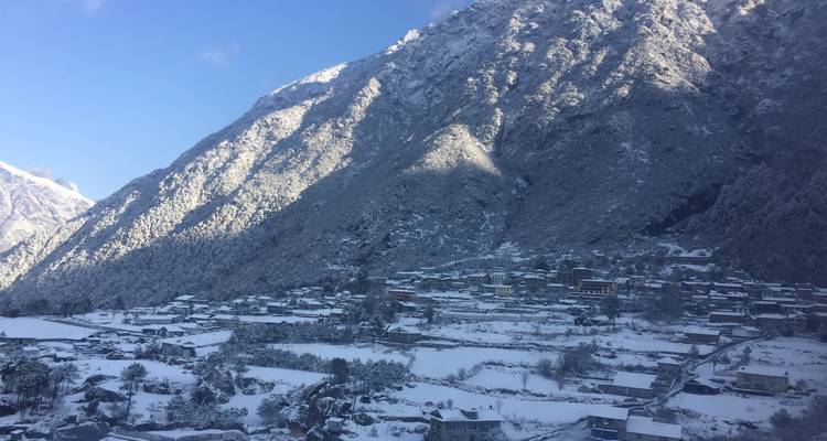 Snow-covered mountain village under a blue sky.