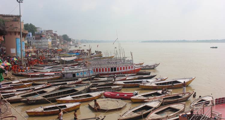 Een drukke rivieroever met talrijke boten in Varanasi.