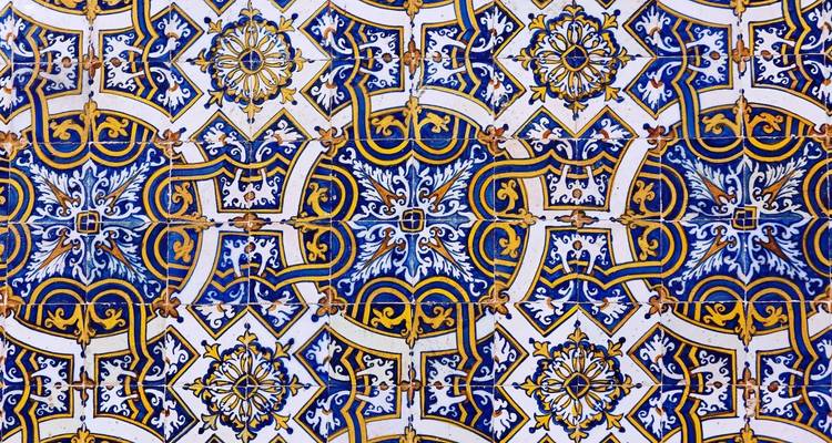Primer plano de un intrincado patrón de azulejos portugueses azules, blancos y amarillos.