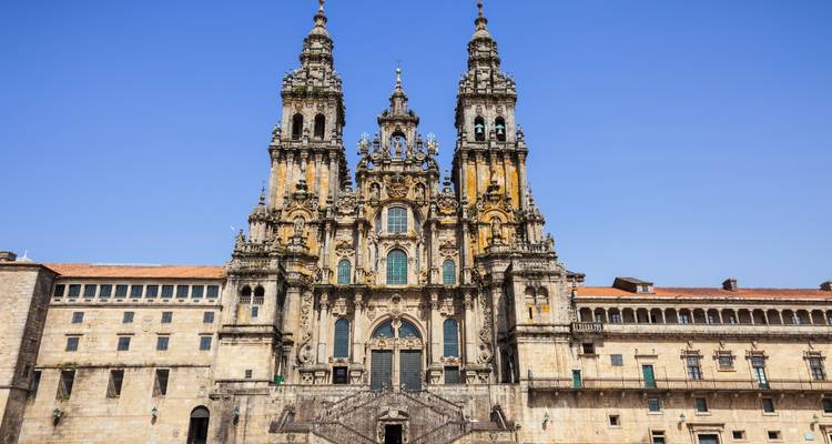 Vue de face de la majestueuse Cathédrale de Santiago de Compostela sous un ciel bleu dégagé.