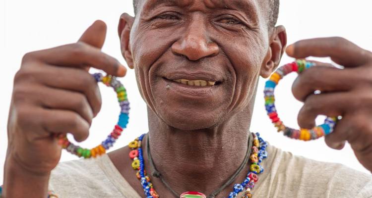 Portrait d'une personne tenant des bijoux colorés en perles.