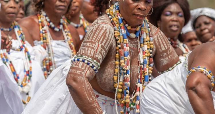 Danse traditionnelle avec des personnes portant des tenues perlées et de la peinture corporelle.