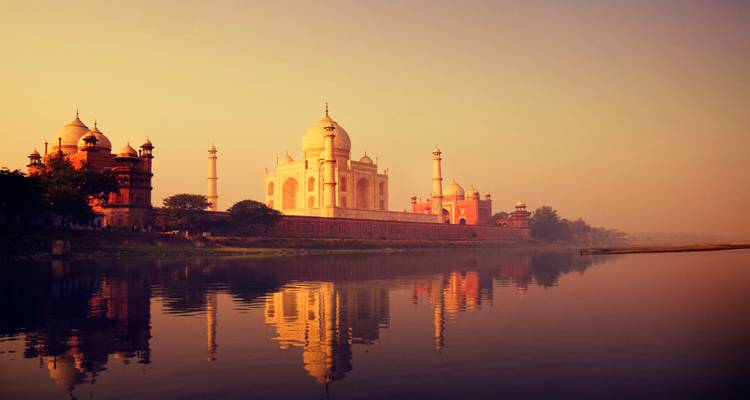 Taj Mahal le long de la rivière au coucher du soleil