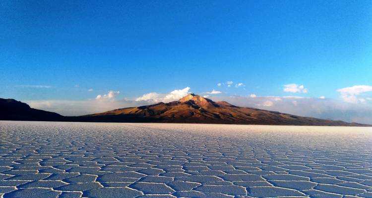 Una vasta planicie salina con una montaña en el fondo.
