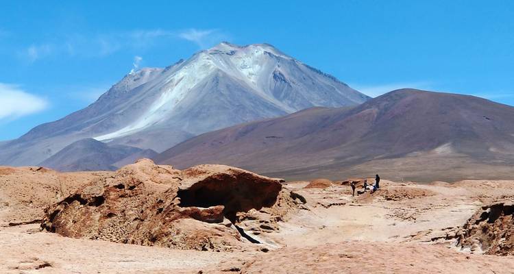 Un paisaje árido con formaciones rocosas y una montaña.