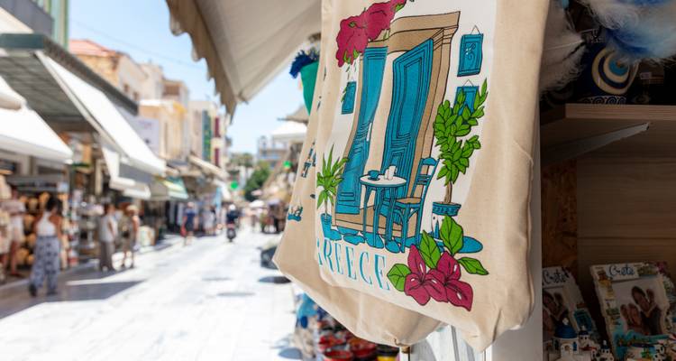 Bolsa ilustrada con motivo de puerta azul cuelga afuera de una tienda de souvenirs.