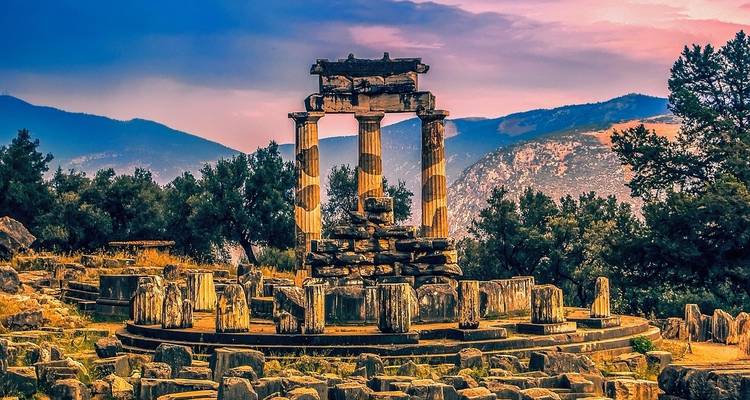 Ruinas de un templo con montañas de fondo en Delfos.
