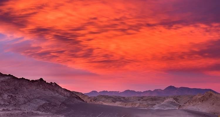 Dramatic red sky over desert landscape.