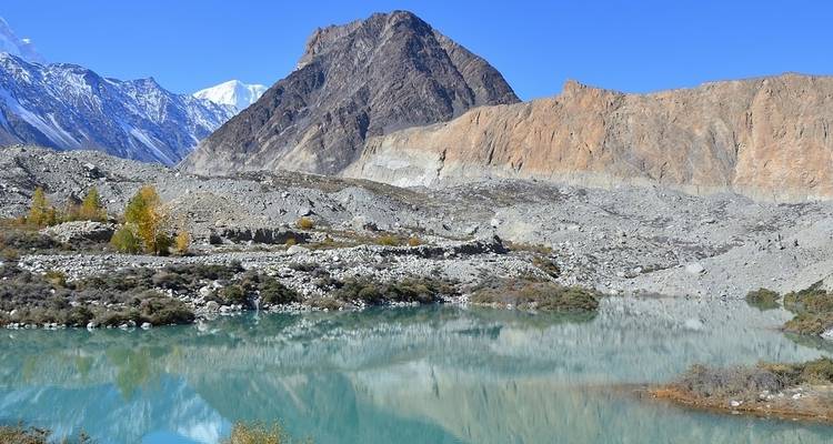 Magnifique lac niché entre des montagnes rocheuses sous un ciel dégagé.