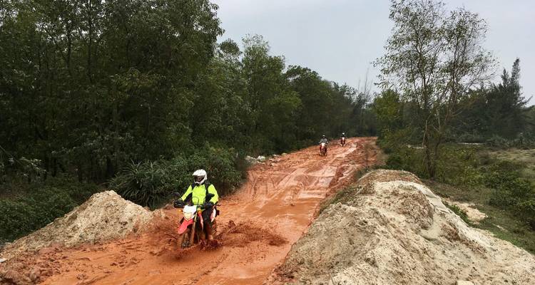 Des gens qui font de la moto sur un chemin boueux.