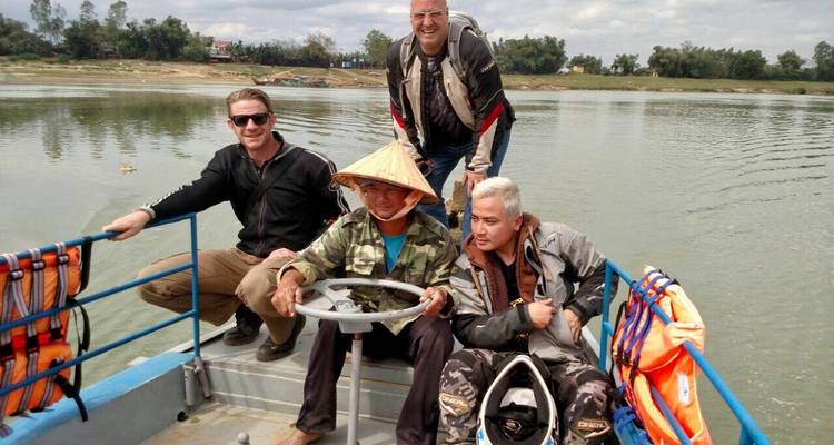 Des gens sur un bateau de rivière, l'un portant un chapeau traditionnel.
