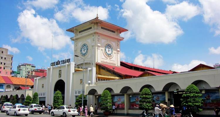 Ben Thanh Market with blue skies and people bustling around.