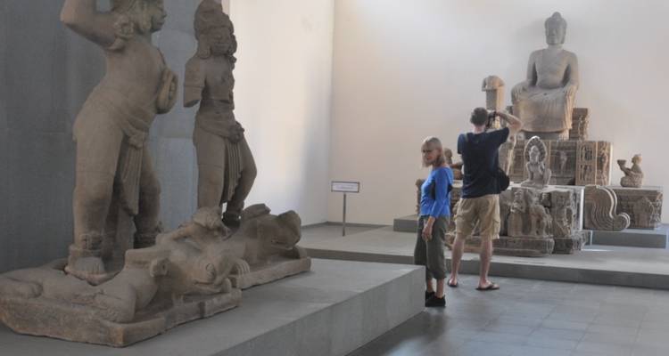 People observing sculptures in a museum setting